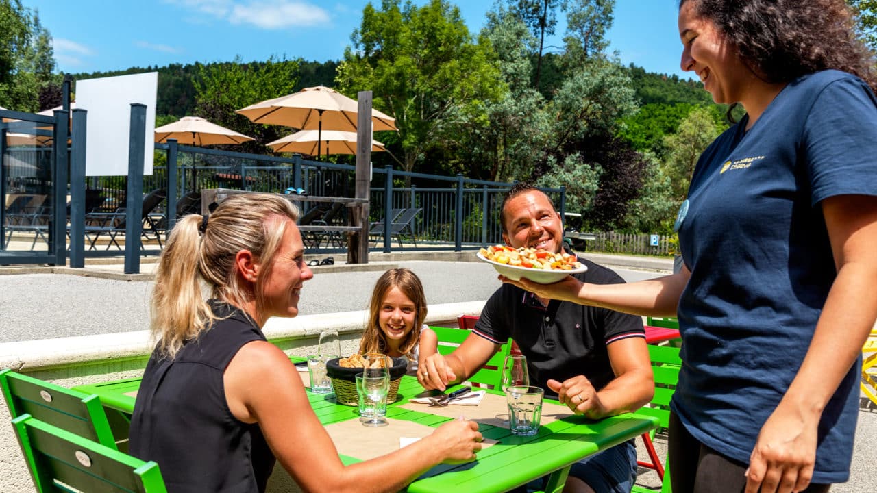 Terrasse du restaurant du camping La Serre en Ariège, avec ses tables dressées en plein air